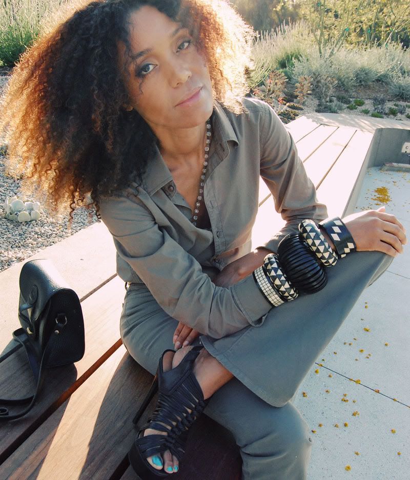 Ndoema wears J Brand jeans in khaki, G-Star Raw Denim shirt, l.a.m.b. platform sandals, classic dooney bourke leather handbag and large ethnic black and white horn and wood bracelets.